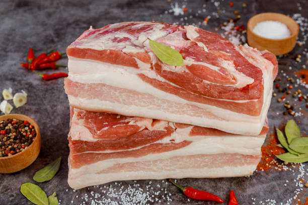 istock Boneless raw pork belly on dark background. 1388215082