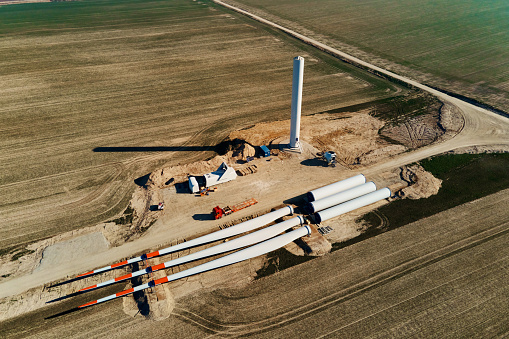 Windmill generator wing prepared for assembling on ground, Construction site for wind power generator building, Green power and renewable energy