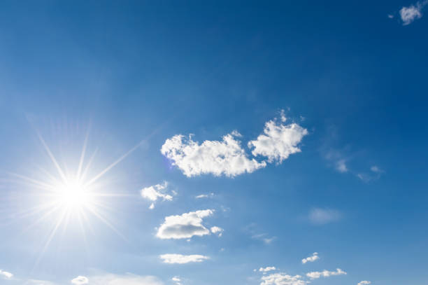 istock Sunny background, blue sky with white clouds and sun 1388223481
