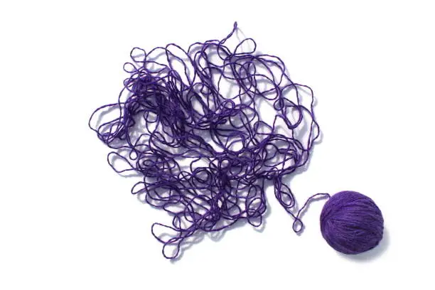Photo of Abstract texture tangled threads of lilac color with a ball on a white background.