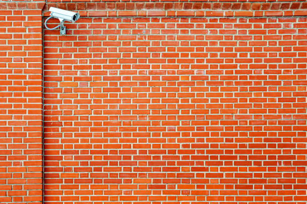 surveillance video camera on the background of a red brick wall.