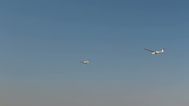 Ultra light, cessna plane drag on glider with prolonge rope on blue sky. Sport, aviation background