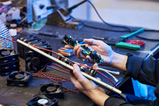 istock Repairing Hardware Equipment. Repair Shop and Worker with Tools.  Microchip and Circuit Board. Testing Modern Digital Device on Desk . Electronic Devices Concept. 1388227563