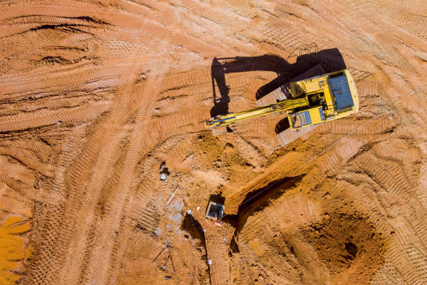 istock Construction of storm water pits sanitary sewer system excavator working backhoe digs ground 1388227626