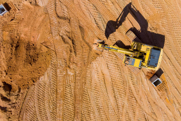 istock Excavator working at backhoe digs ground for laying concrete pipes on construction site on earthworks 1388227630