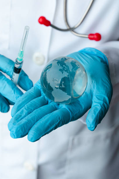 istock Doctor Holding Globe with Vaccine 1388227646