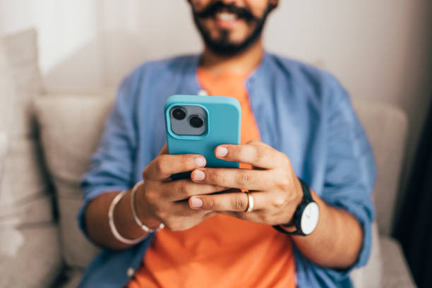 istock A Close Up Shot Of An Unrecognizable Casually Dressed Man Smiling While Texting To Somebody On His New Green Mobile Phone 1388227897