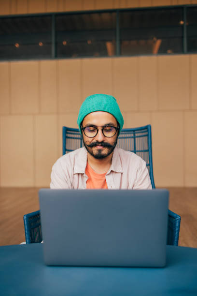 istock A Happy Casually Dressed Businessman With Moustaches Working On His Computer 1388227928