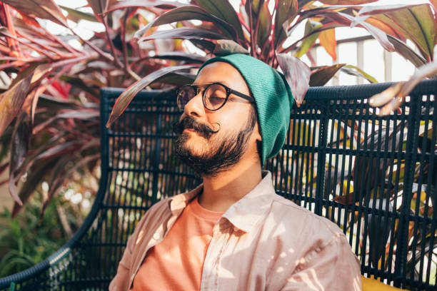 istock A  Casually Dressed Man With Moustaches Smiling While Sitting Outdoors In A Comfortable Chair With His Eyes Closed 1388227948