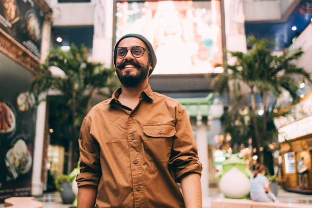 A Happy Casually Dressed Man With Moustaches Walking Through The City