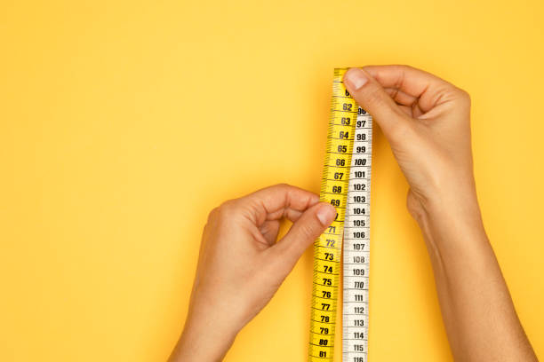 istock Woman Holding Tape Measure 1388229763