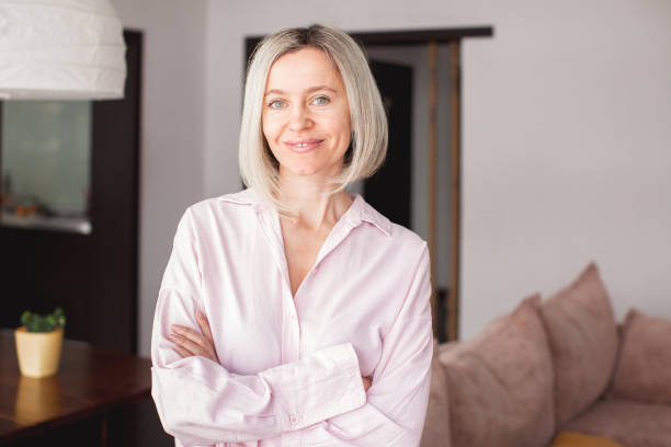 istock Smiling middle aged mature woman looking at camera at home 1388230652