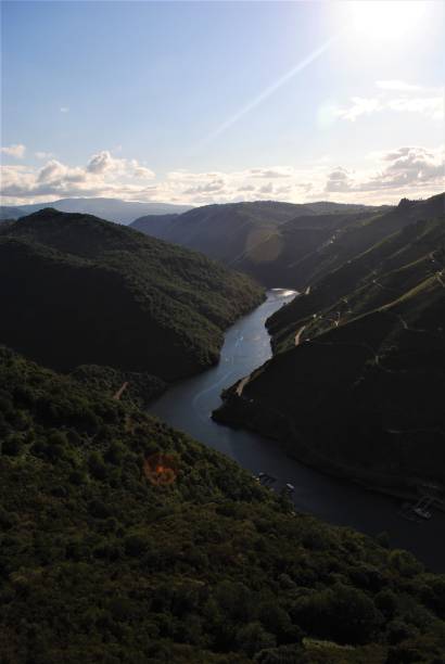 istock Scenic view of river amidst mountains against sky. 1388230931