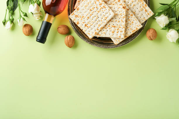 istock Passover celebration concept. Matzah, red kosher wine, walnut and spring beautiful rose flowers. Traditional ritual Jewish bread on light green background. Passover food. Pesach Jewish holiday. 1388231266