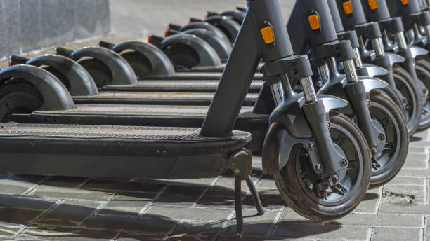 istock Electric scooters waiting at the curb ready to be rented and driven away. Several blue e-scooters stand in a row for rent. 1388232606