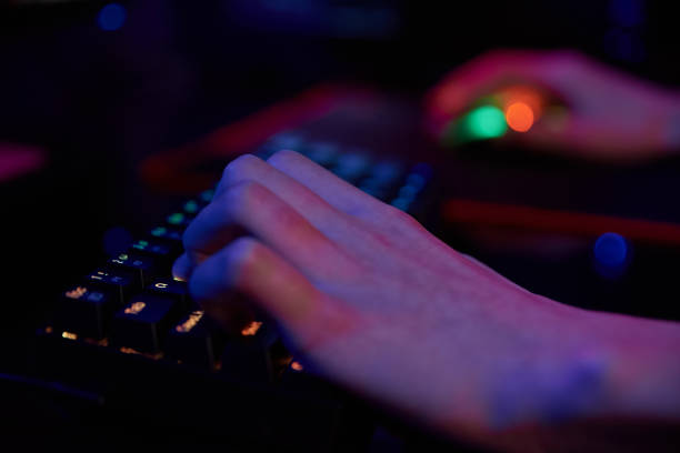 istock Gamer play computer game, use rgb neon colored keyboard 1388233889