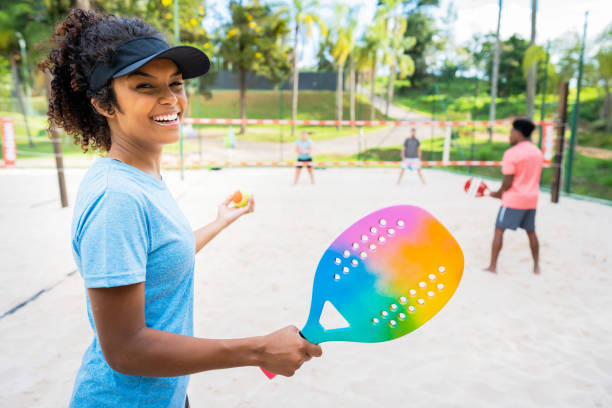 grupo de amigos jogando tênis de praia - tennis women action lifestyles - fotografias e filmes do acervo