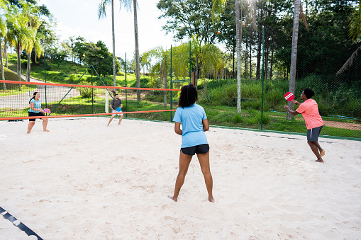 Group of friends playing beach tennis