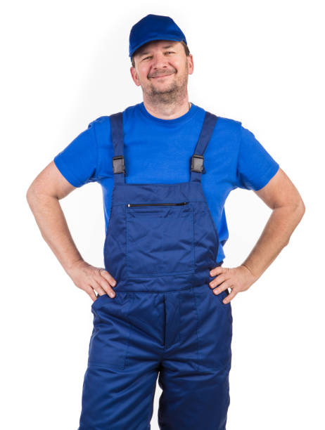 istock A worker in bib overalls with his hands on his waist. 1388235727