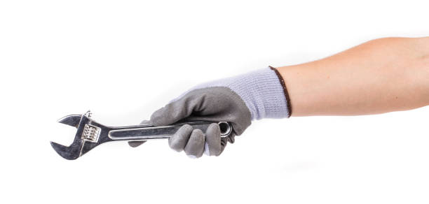 istock A gloved hand holds an adjustable wrench. 1388236002