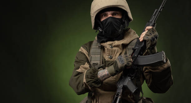 istock Soldier with Rifle Against Green Background 1388239331
