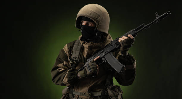 istock Soldier with Rifle Against Green Background 1388239334