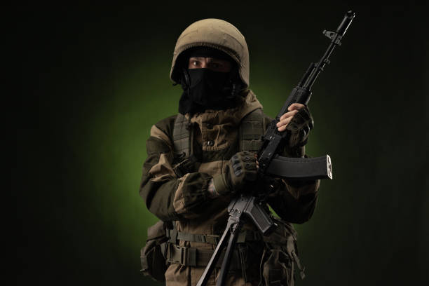 istock Soldier with Rifle Against Green Background 1388239337