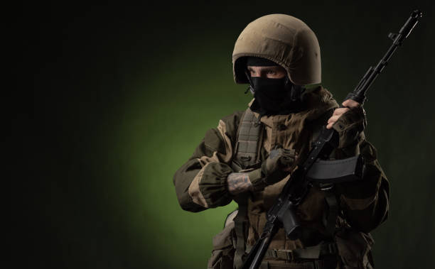 istock Soldier with Rifle Against Green Background 1388239339