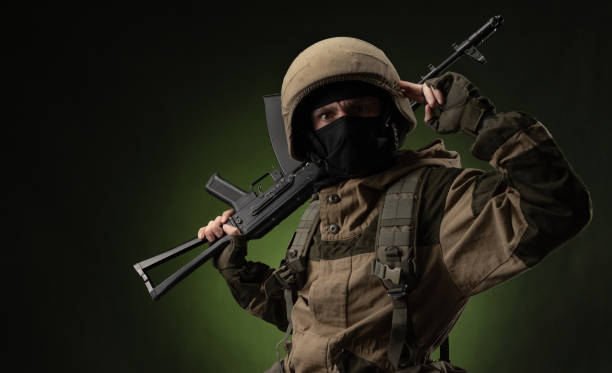 istock Soldier with Rifle Against Green Background 1388239343