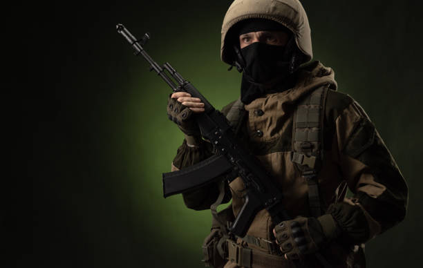 istock Soldier with Rifle Against Green Background 1388239344