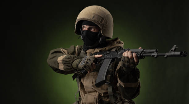 istock Soldier with Rifle Against Green Background 1388239347
