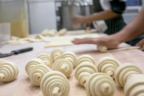 istock Pastry Chef Rolling Fresh Raw Croissant Dough. 1388240497
