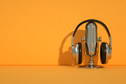 3d rendering of Retro Old Microphone and Headphones, Vintage Style, Orange Color Background.