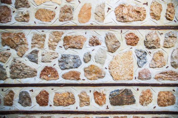 background of concrete gray wall with colored decorative stones.