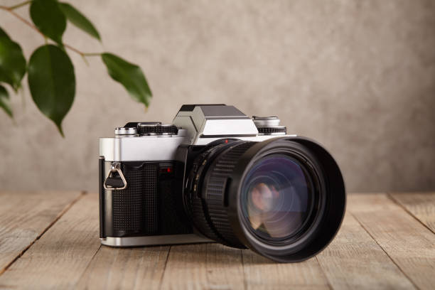 istock SLR Single-lens reflex professional camera on wooden table and concrete wall background 1388243280