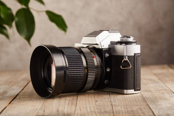 istock SLR Single-lens reflex professional camera on wooden table and concrete wall background 1388243284