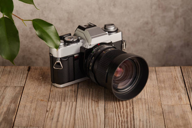 istock SLR Single-lens reflex professional camera on wooden table and concrete wall background 1388243451