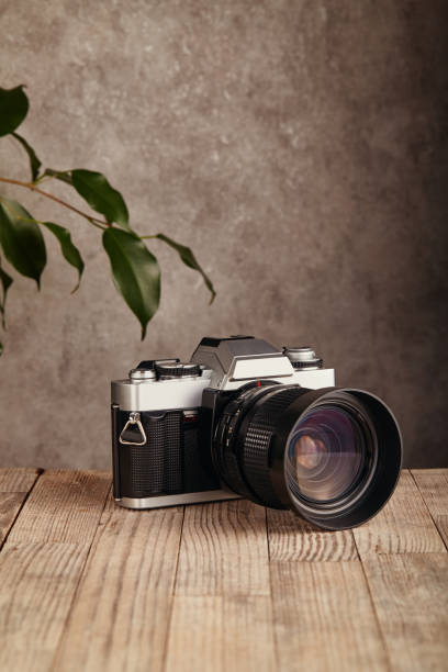 istock SLR Single-lens reflex professional camera on wooden table and concrete wall background 1388243492