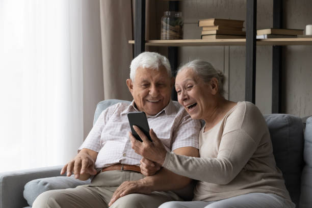 istock Happy excited older married couple using smartphone 1388244213
