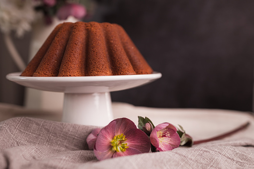 Beautifully decorated kugelhopf cake placed on a cake stand and served on a table