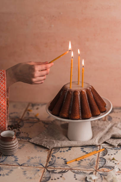 mujer encendiendo velas ceremoniales en un pastel de kugelhopf - chocolate bundt cake fotografías e imágenes de stock