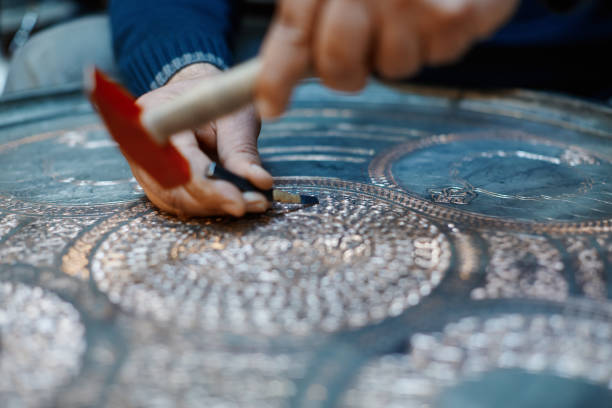 istock Craftsman doing engravings on a metal plate 1388245482