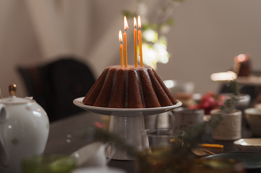 Ceremonial kugelhopf cake placed on a table and having candles placed on it