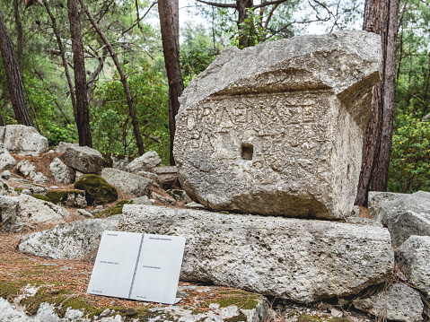 Phaselis, Turkey - May 19, 2018. Stone with carved dedicatory inscription. Ancient city of Phaselis. Famous landmark in Turkey.