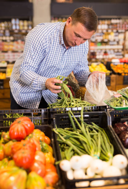 istock Man choosing green beans in supermarket 1388248249