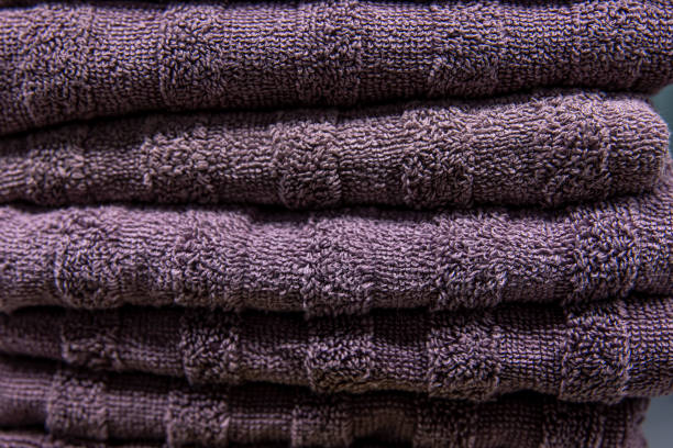 istock Textured violet bath towels stacked close up. 1388248523
