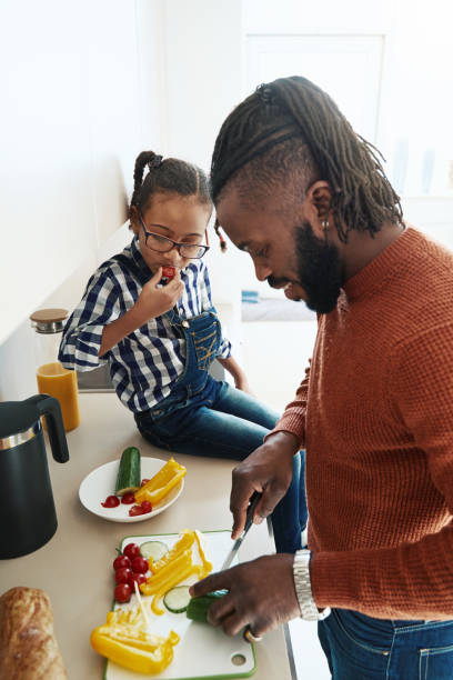 istock Small girl participating in cooking with her father 1388249388