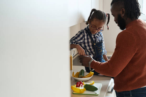 istock Young girl cooking with her father in the kitchen 1388249403
