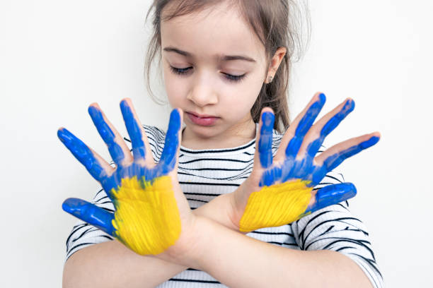 istock Child's hands painted on Ukraine flag colors. 1388250382