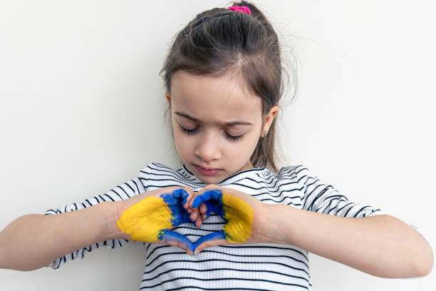 istock Child's hands painted on Ukraine flag colors. 1388250383